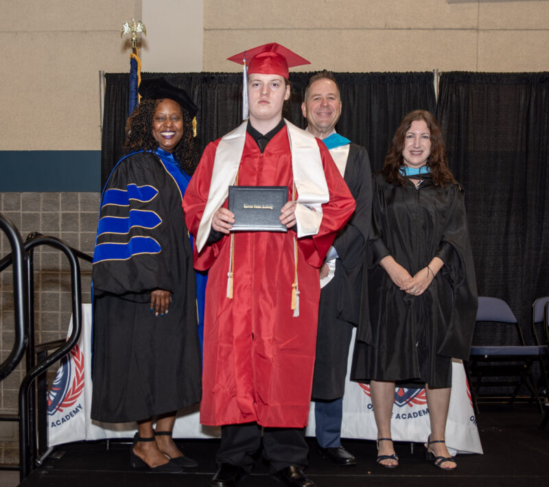 student with teachers receiving the diploma